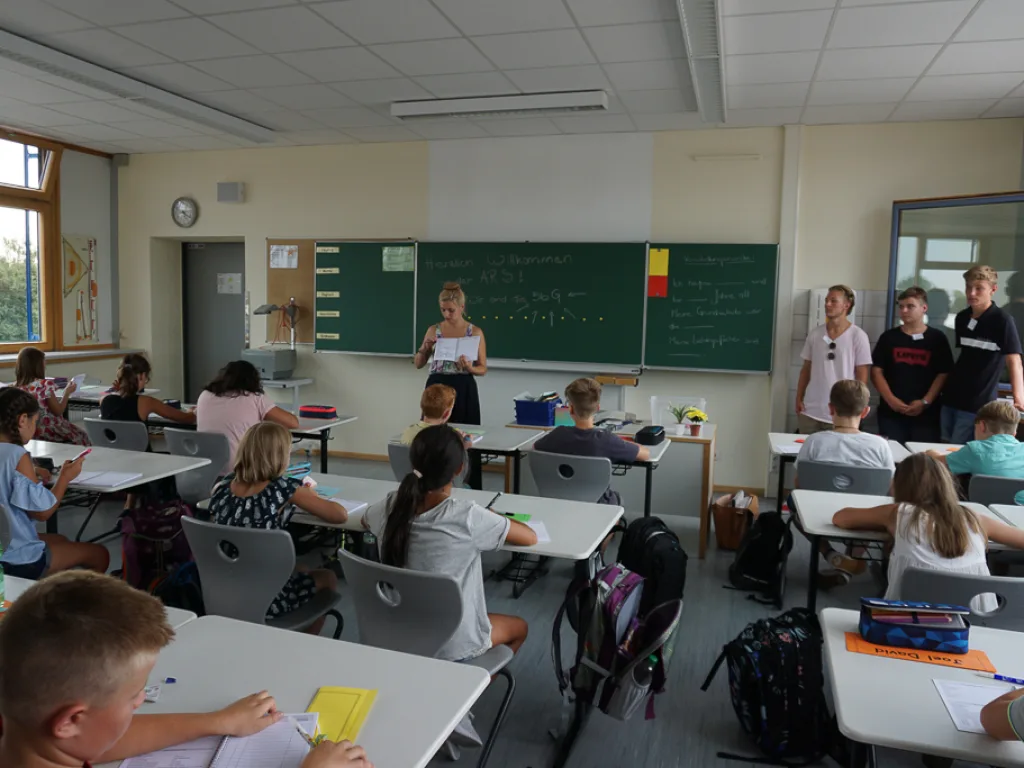 Zwei Lehrkräfte stehen an der Tafel vor der Klasse.